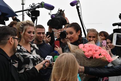 Москва. Телеведущая Ольга Бузова (справа) вручила ключи победительнице `гива` - девушке-блогеру.