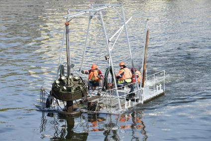 Москва. Рабочие убирают на зиму плавучие фонтаны Водоотводного канала.