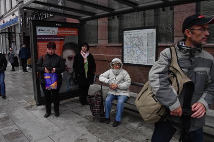 Москва. Пассажиры на остановке общественного транспорта.