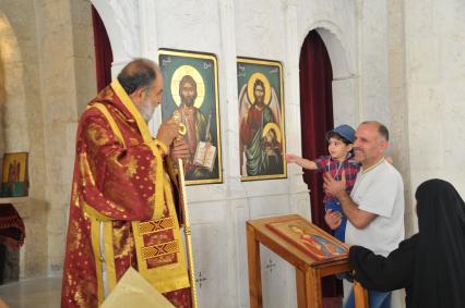 Сирия, Маалюл.  Священник проводит службу в восстановленном  после захвата и разрушения боевиками храме в Маалюла.