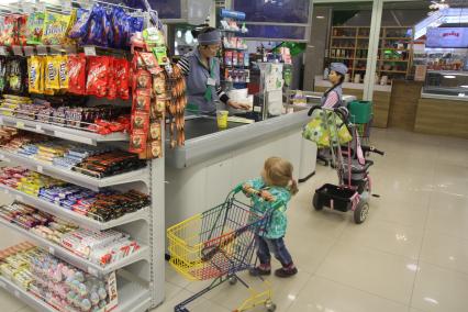 Иркутск. Девочка с продуктовой тележкой в супермаркете.