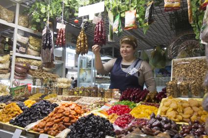 Иркутск.   Женщина торгует орехами и сухофруктами на рынке.