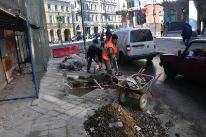 Москва. Укладка тротуарной плитки на улице города.