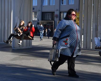 Москва. Девушки качаются на качелях.