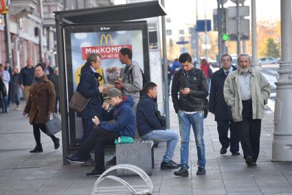 Москва. Прохожие на остановке общественного транспорта.