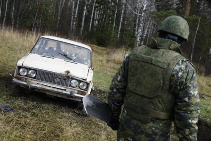 Свердловская область. Криминалист следственного комитета обследует взорванный и обстрелянный автомобиль с менекеном, во время учений следователей-криминалистов СУ СК России