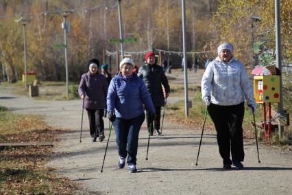 Иркутск. Горожане во время скандинавской ходьбы в парке.