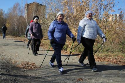 Иркутск. Горожане во время скандинавской ходьбы в парке.