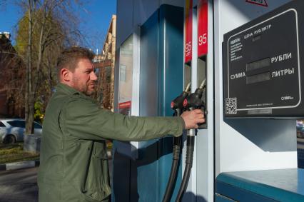 Санкт-Петербург. Водитель заправляет автомобиль на автозаправочной станции.