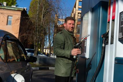 Санкт-Петербург. Водитель заправляет автомобиль на автозаправочной станции.