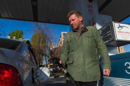 Санкт-Петербург. Водитель заправляет автомобиль на автозаправочной станции.