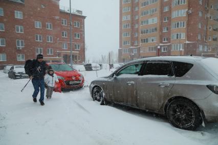 Красноярск.  Мужчина с ребенком во дворе дома.