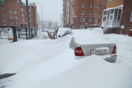 Красноярск.  Занесенные снегом машины на стоянке во дворе дома.