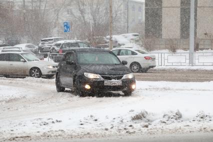 Красноярск. Занесенной снегом машины на улице города.