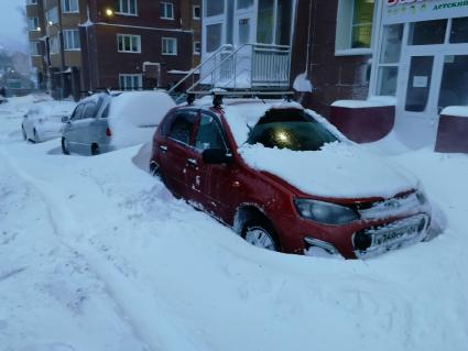 Красноярск.  Занесенные снегом машины на стоянке во дворе дома.