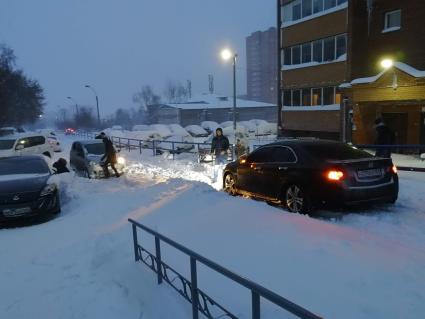 Красноярск.  Занесенные снегом машины на стоянке во дворе дома.