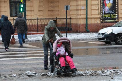 Красноярск.  Женщина с коляской переходит улицу.