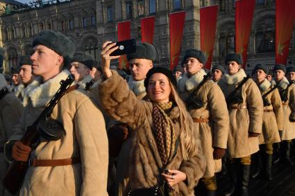 Москва. Девушка фотографируется с участниками марша, посвященного 77-й годовщине военного парада 1941 года, на Красной площади.