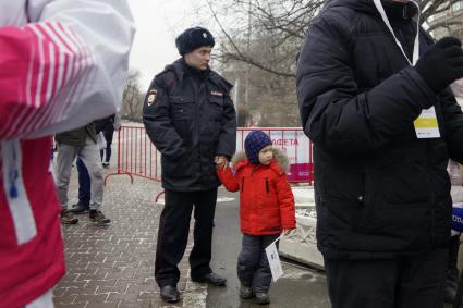 Екатеринбург. Полицейский с ребенком во время эстафеты огня XXIX Всемирной зимней универсиады 2019