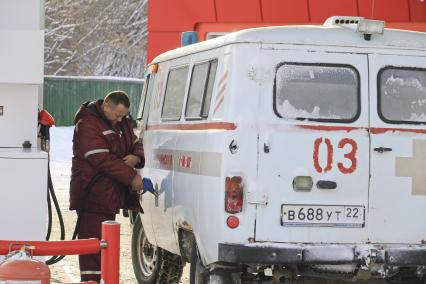 Барнаул. Водитель  заправляет машину скорой помощи на автозаправочной станции.