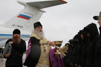 Архангельск.  Священник освящает  призывников на сборном пункте.