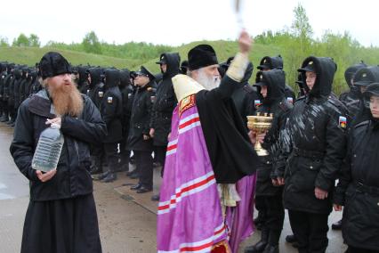 Архангельск.  Священник освящает  призывников на сборном пункте.