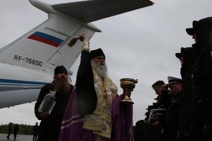 Архангельск.  Священник освящает  призывников на сборном пункте.