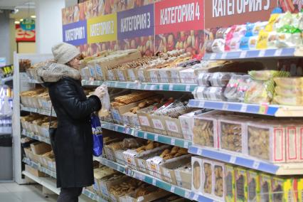 Красноярск. Женщина выбирает продукты в магазине.