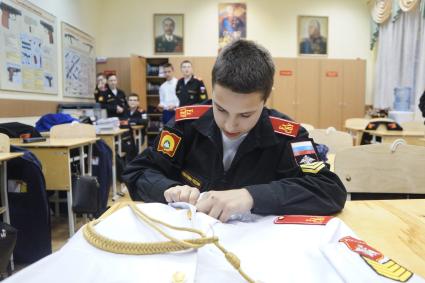 Екатеринбург. Екатеринбургское суворовское военное училище. День открытых дверей. Суворовец подшивает воротничек у мундира