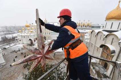 Москва.  Рабочий украшает главную новогоднюю  елку страны на Соборной площади Московского Кремля.