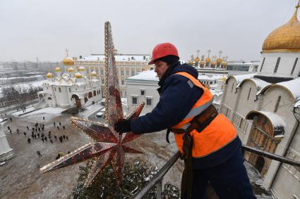 Москва.  Рабочий украшает главную новогоднюю  елку страны на Соборной площади Московского Кремля.