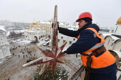 Москва.  Рабочий украшает главную новогоднюю  елку страны на Соборной площади Московского Кремля.