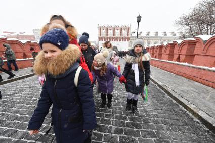 Москва.  Дети идут в Кремль по Троицкому мосту.