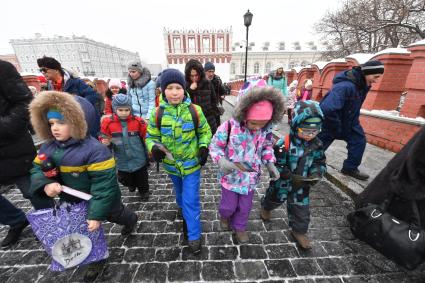 Москва.  Дети идут в Кремль по Троицкому мосту.