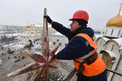 Москва.  Рабочий украшает главную новогоднюю  елку страны на Соборной площади Московского Кремля.