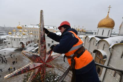 Москва.  Рабочий украшает главную новогоднюю  елку страны на Соборной площади Московского Кремля.