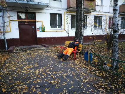 Москва. Дворник спит  на скамейке.