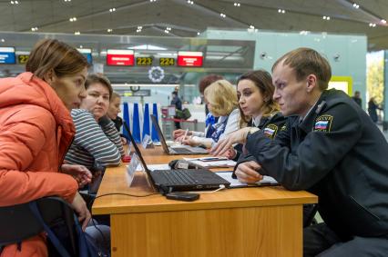 Санкт-Петербург.  Пассажиры во время проверки наличия возможных долгов через базу судебных приставов в аэропорту `Пулково` в рамках общероссийского рейда ФССП России `Без долгов теплее` по взысканию задолженностей в пользу предприятий ТЭК.