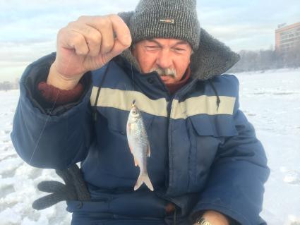 Московская область. Мужчина держит пойманную рыбу.