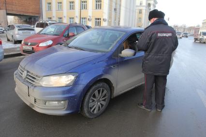 Иркутск.  Сотрудник  полиции   проверяет документы у водителя.