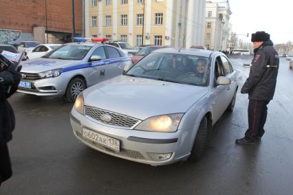 Иркутск.  Сотрудник  полиции проверяет документы у водителя.