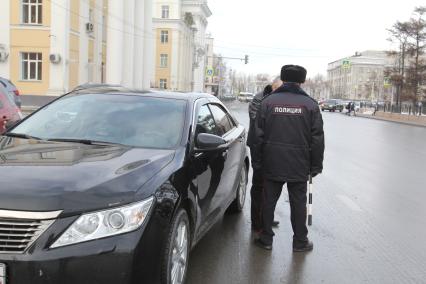 Иркутск.  Сотрудник  полиции проверяет документы у водителя.