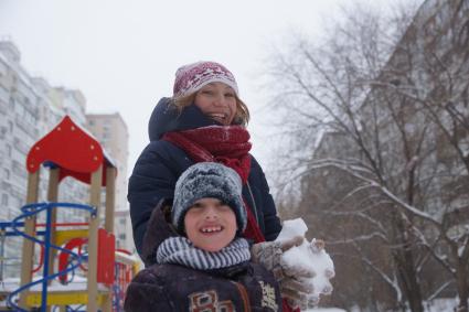 Самара.  Женщина гуляет с ребенком на детской площадке.