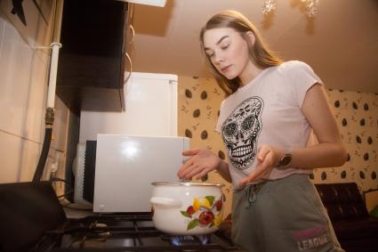 Пермь. Девушка на кухне у газовой плиты.