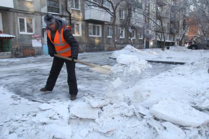 Иркутск. Дворник расчищает двор от снега.