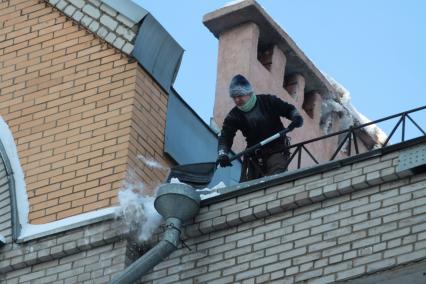 Иркутск. Сотрудники коммунальных служб  сбрасывают снег с крыш.