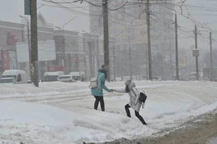 Тула. Девушки перелезают через сугроб на одной из улиц города.