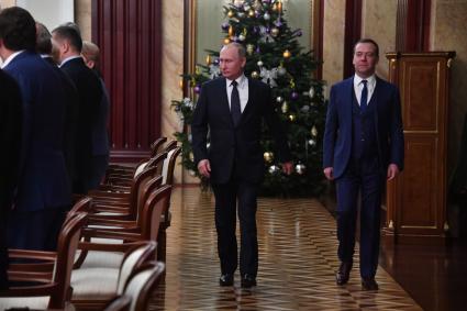 Москва. Президент РФ Владимир Путин и премьер-министр РФ Дмитрий Медведев (слева направо) во время предновогодней встречи с членами правительства РФ.