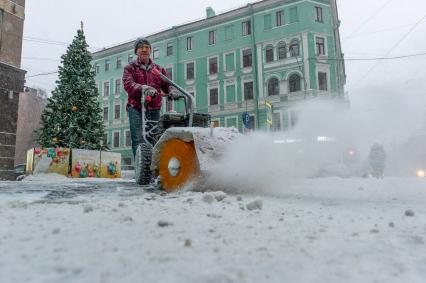 Санкт-Петербург. Дворник убирает снег на улице.