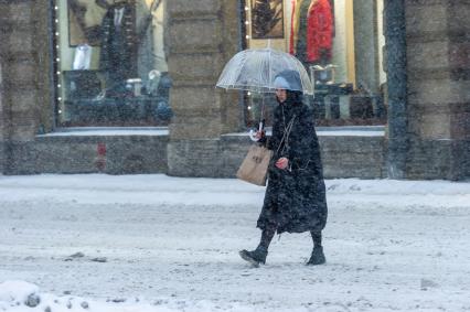 Санкт-Петербург. Женщина под зонтом на заснеженной улице.